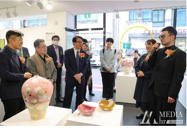 지난8일 전시회 개관 행사에 참여한 전성수 서초구청장이 참여작가의 작품 설명을 듣고 있다.