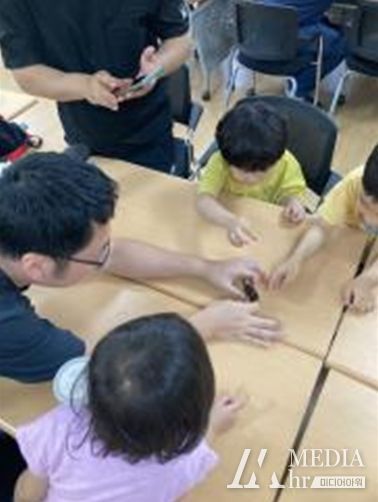 인천 부평육아종합지원센터가 지난 6월 마련한 ‘부평 아빠는 진짜 엄지 척’ 숲 체험 프로그램에 참여한 아이들과 아빠들이 장수풍뎅이를 관찰하고 있다.