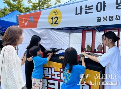 초등학생들에게 사격하는 방법을 설명하고 있는 청소년들